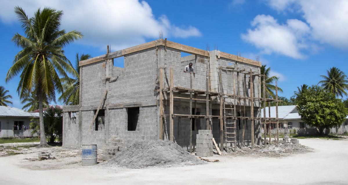 Maison en construction dans un village des Comores, échafaudage en bois et palmiers